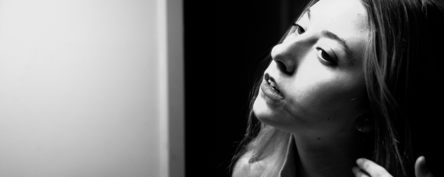 girl staring in mirror in black and white